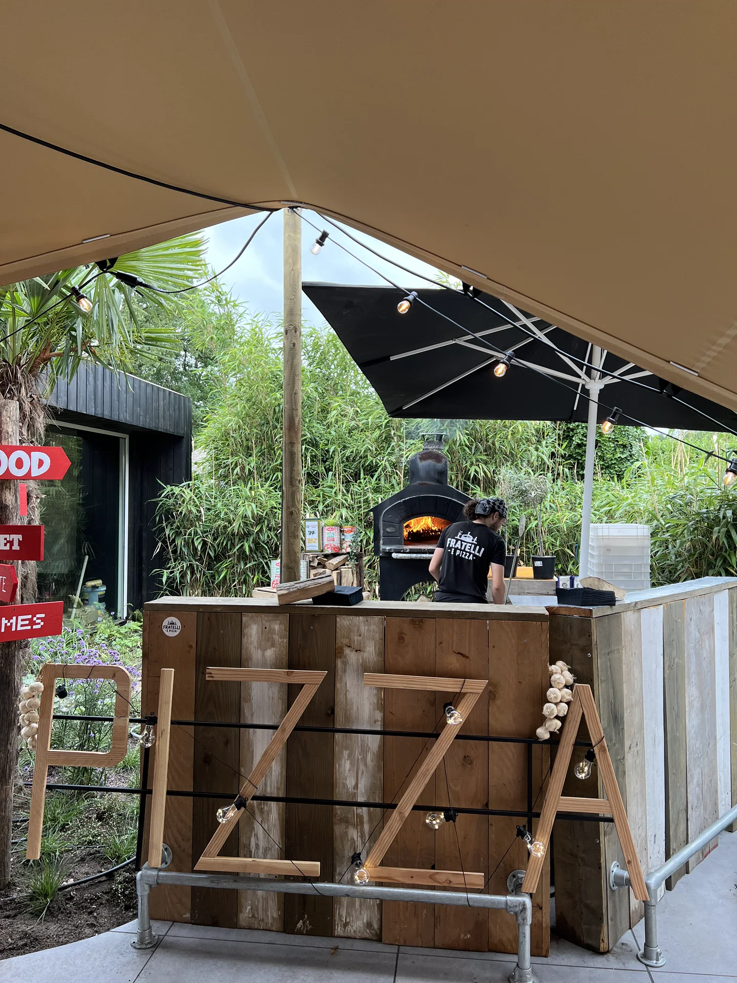 Pizzabakker van Fratelli e Pizza aan het werk bij een houtoven op locatie