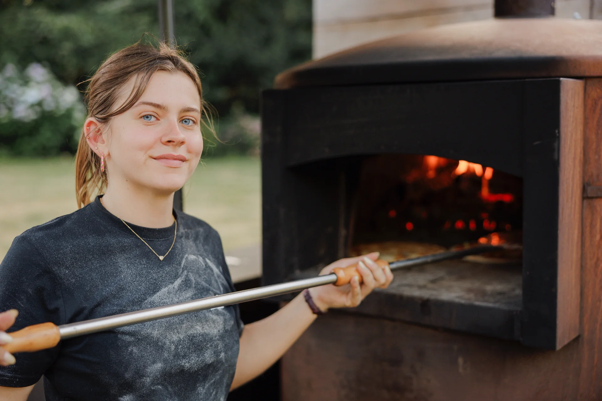 Pizzabakker van Fratelli e Pizza bij een houtgestookte oven