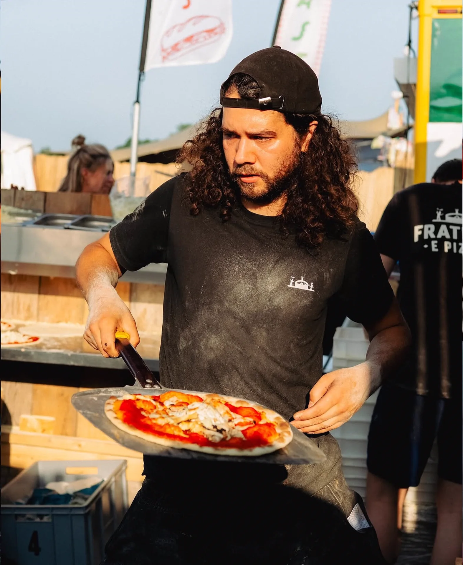 Pizzabakker van Fratelli e Pizza bereidt een pizza op een festival
